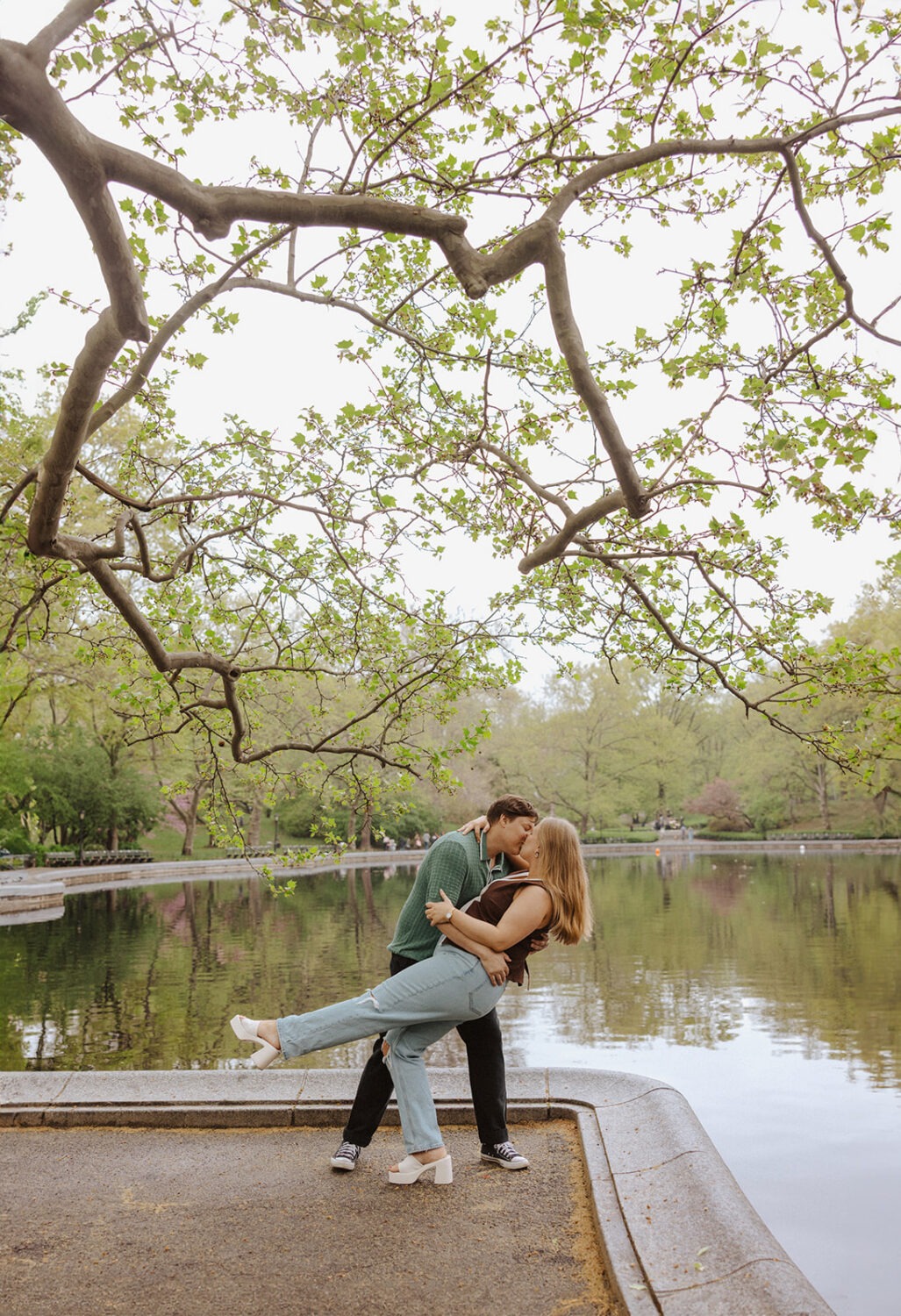 couple pose in front of water at Central Park