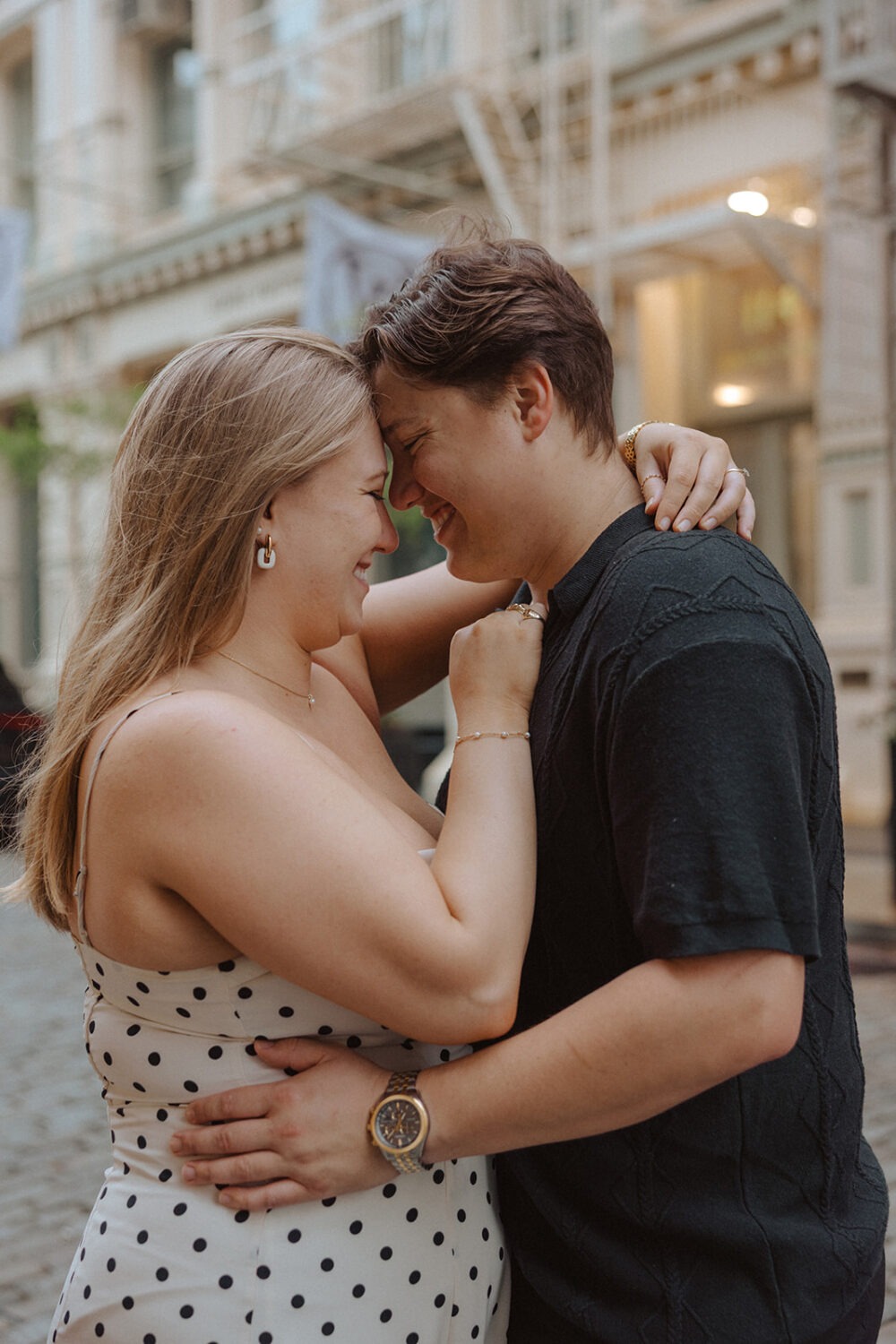 couple embrace while taking rainy engagement photos