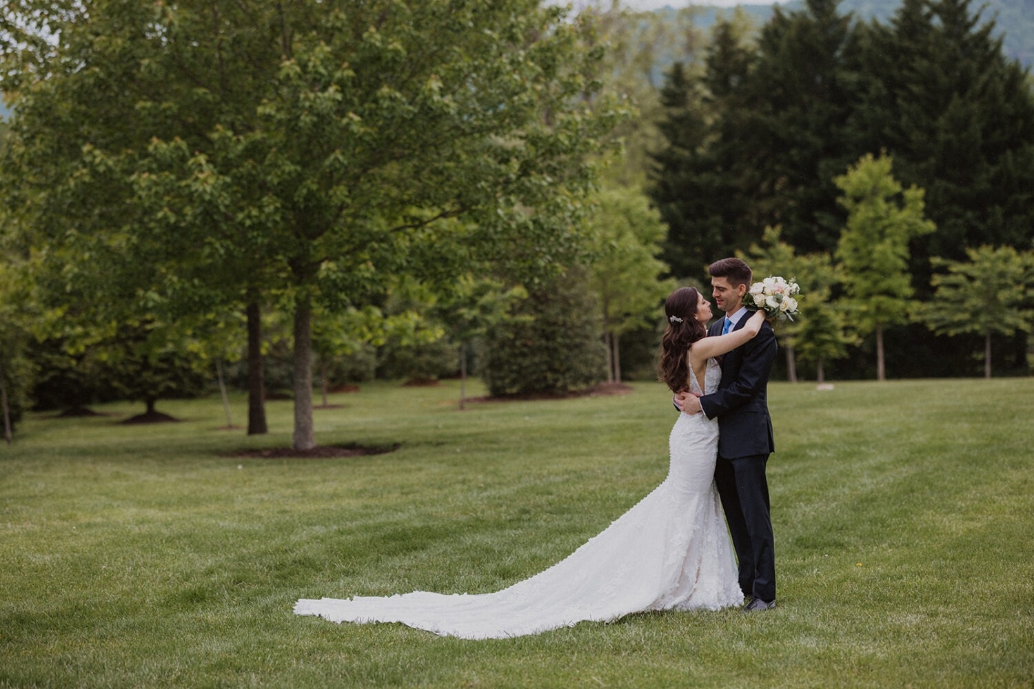 couple embrace in the open green field
