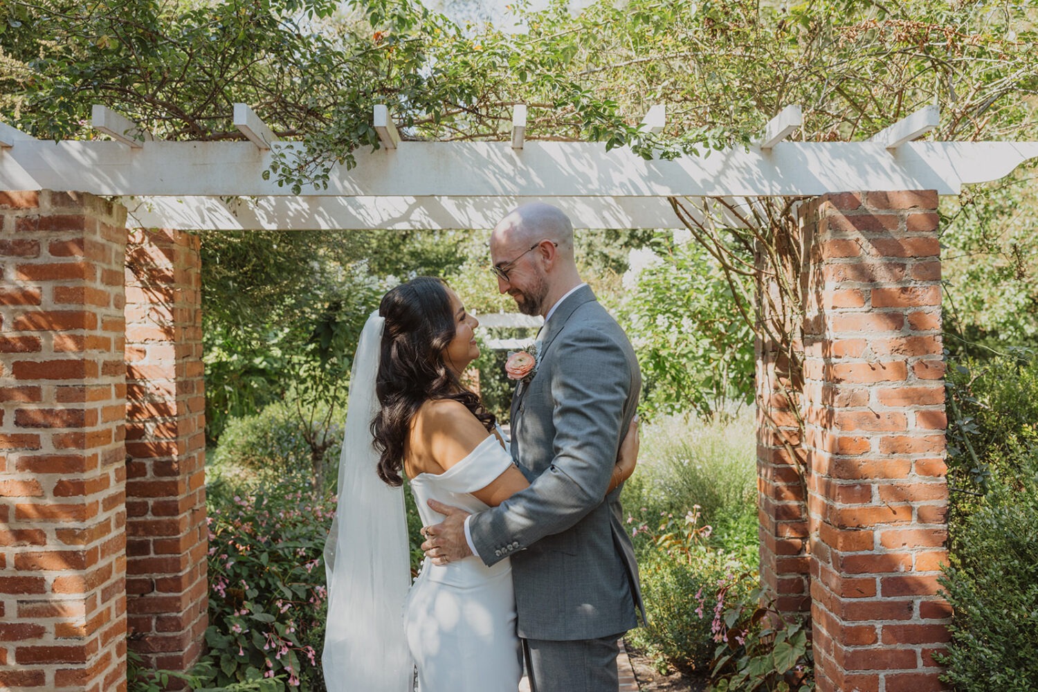 couple embrace by arch at River Farm Alexandria Virginia