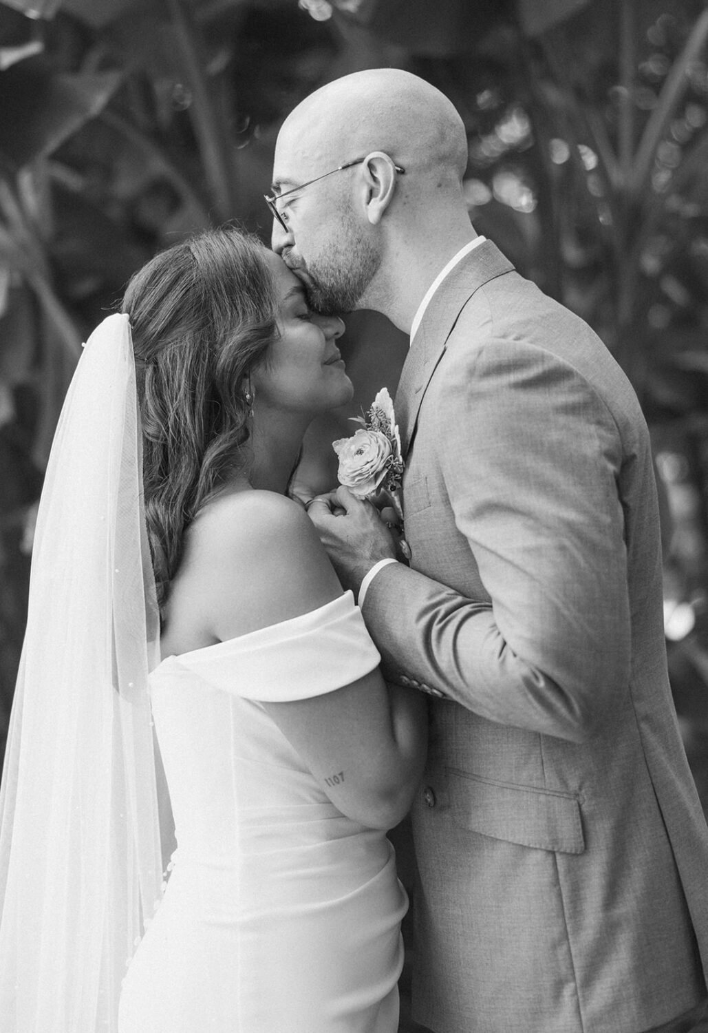 groom kissing bride on forehead