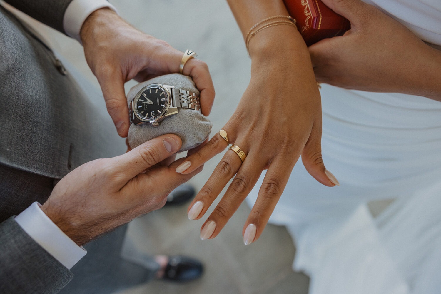 showing off wedding gifts to each other including rings and a watch