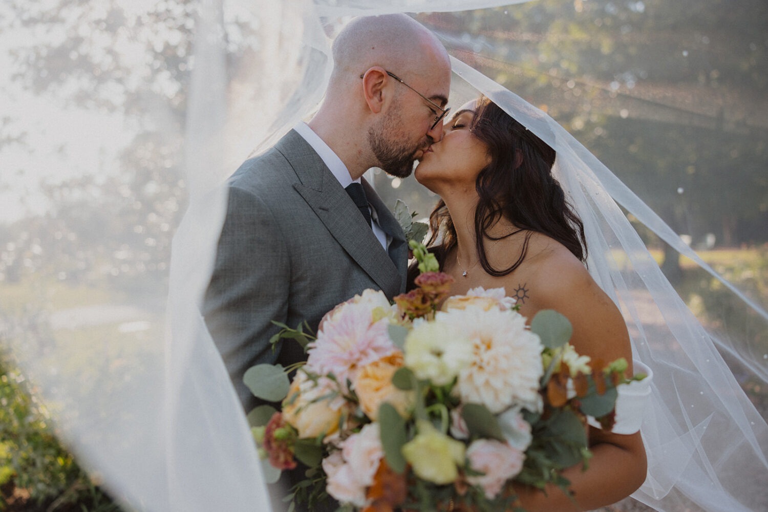 couple kiss under bride's veil