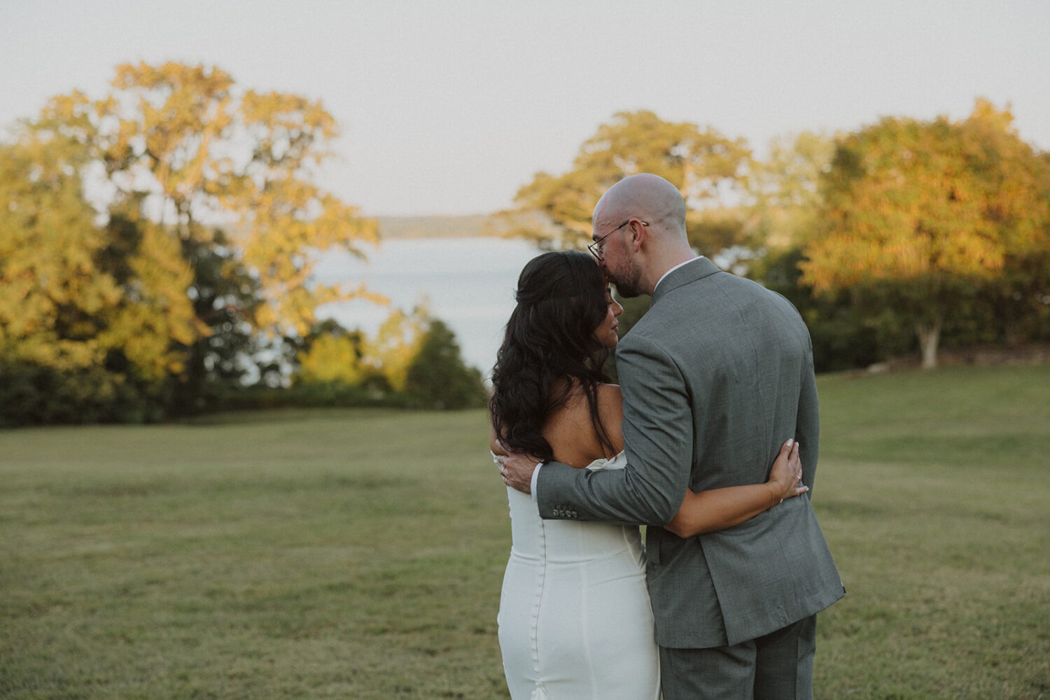 couple embrace and kiss looking at water at River Farm Alexandria Virginia